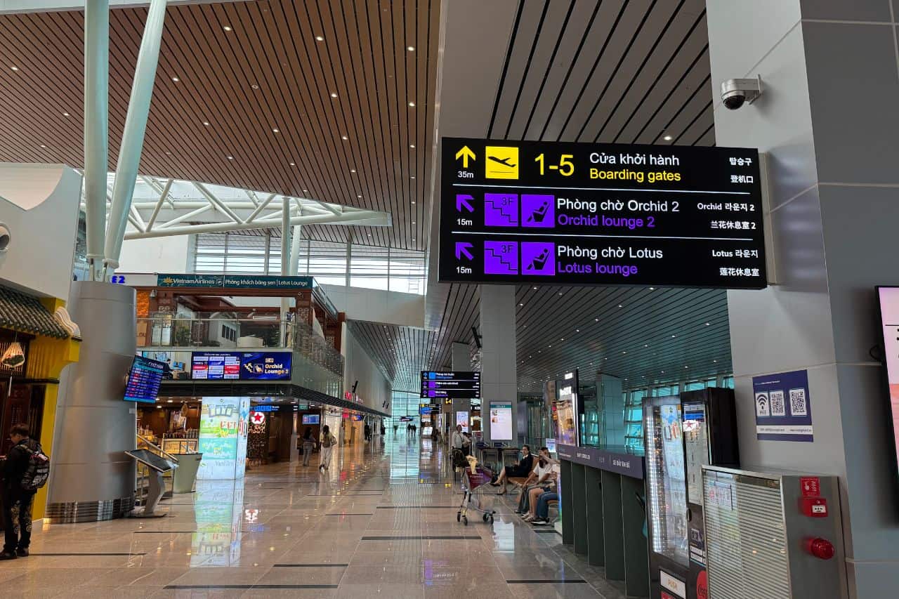 Departure Flight Schedule and Check-In Counters - Da Nang Airport Digital departure board above check-in counters at Da Nang Airport, showing flight details and gate information