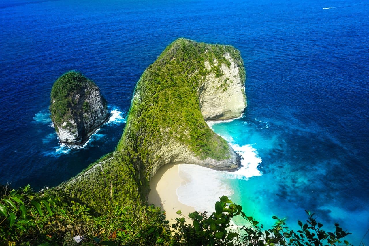 Iconic View of Nusa Penida Famous cliffs and beach at Nusa Penida with deep blue ocean waves crashing on the shore.