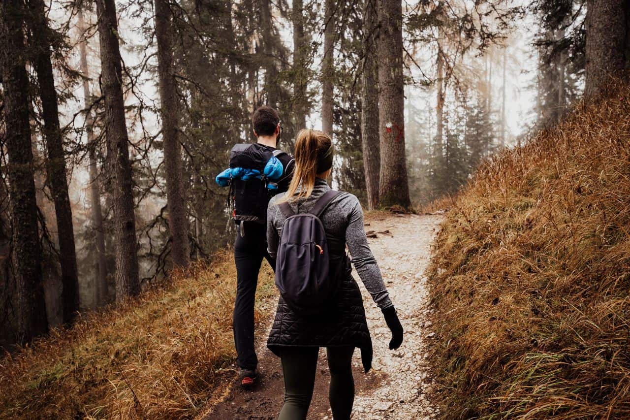 Two hikers walking through a wooded trail in Bagni di Lucca, Tuscany