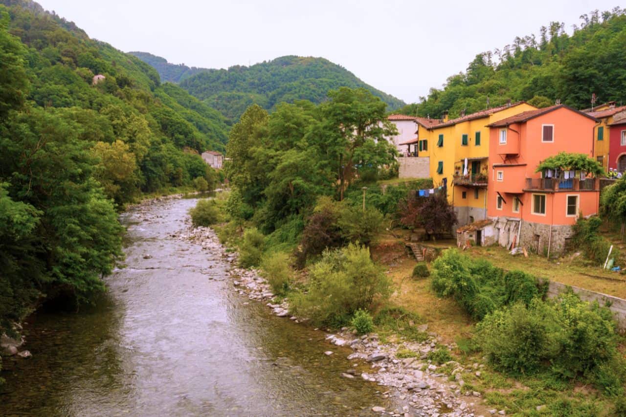 Bright houses lining the banks of the Lima River in Bagni di Lucca, known for rafting