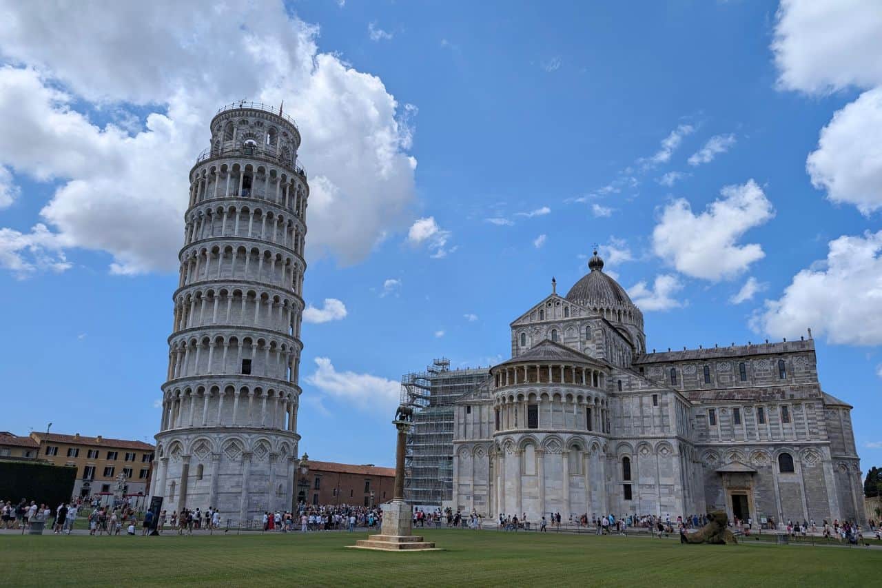 Bright, clear view of the Leaning Tower of Pisa and Pisa Cathedral under a blue sky in Piazza dei Miracoli