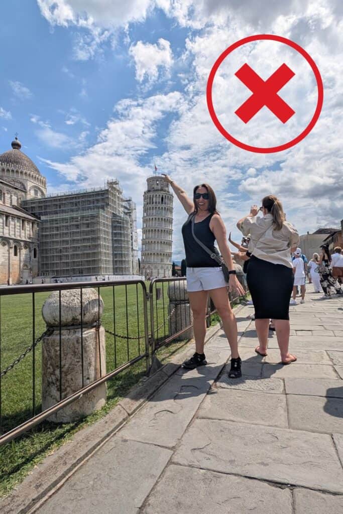 Tourist standing in a crowded area taking photos in front of the Leaning Tower of Pisa with blocked views