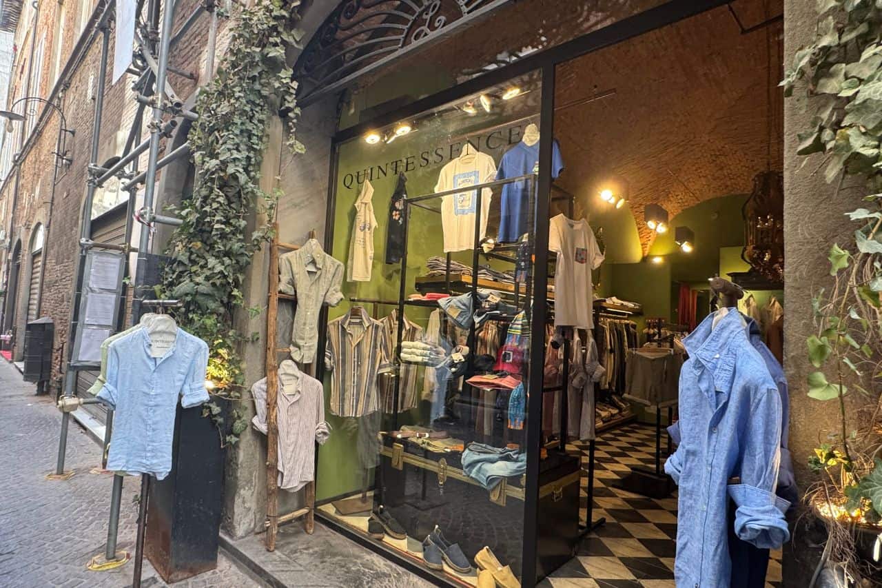 Boutique in Lucca Italy displaying natural linen clothing in soft colors, popular for local window shopping