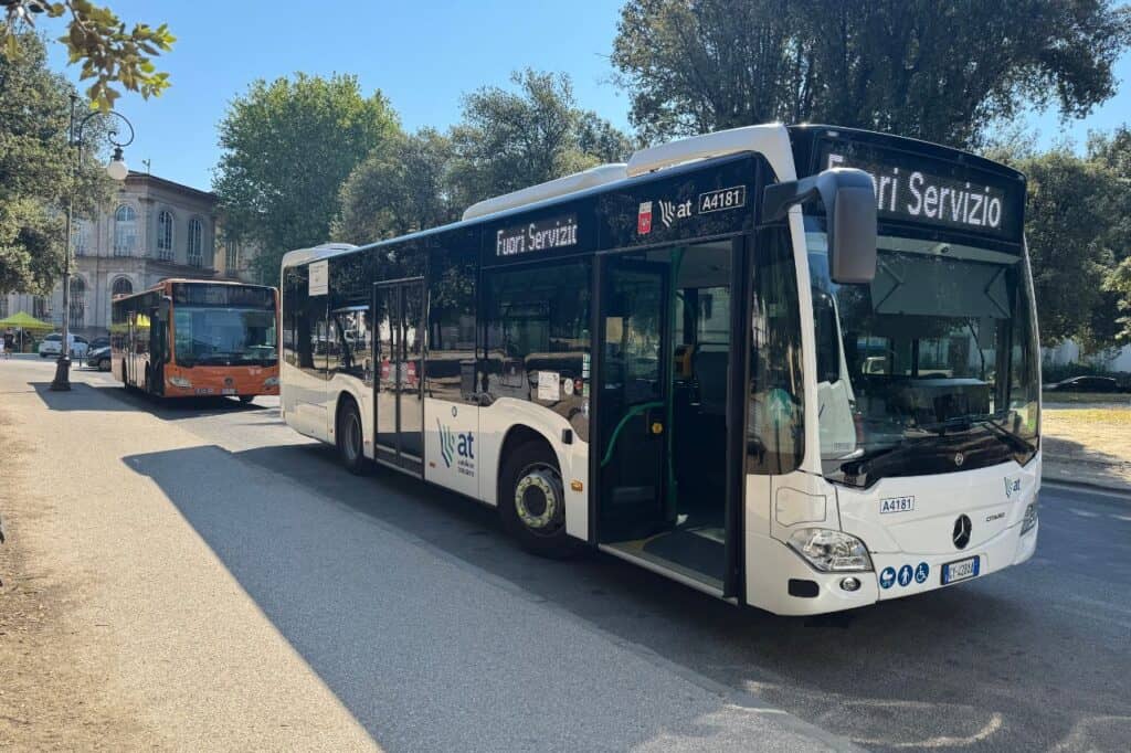 Two buses parked at the Lucca bus terminal near the city center entrance