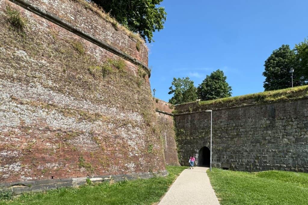 Stone archway entrance leading into the walled city of Lucca Italy
