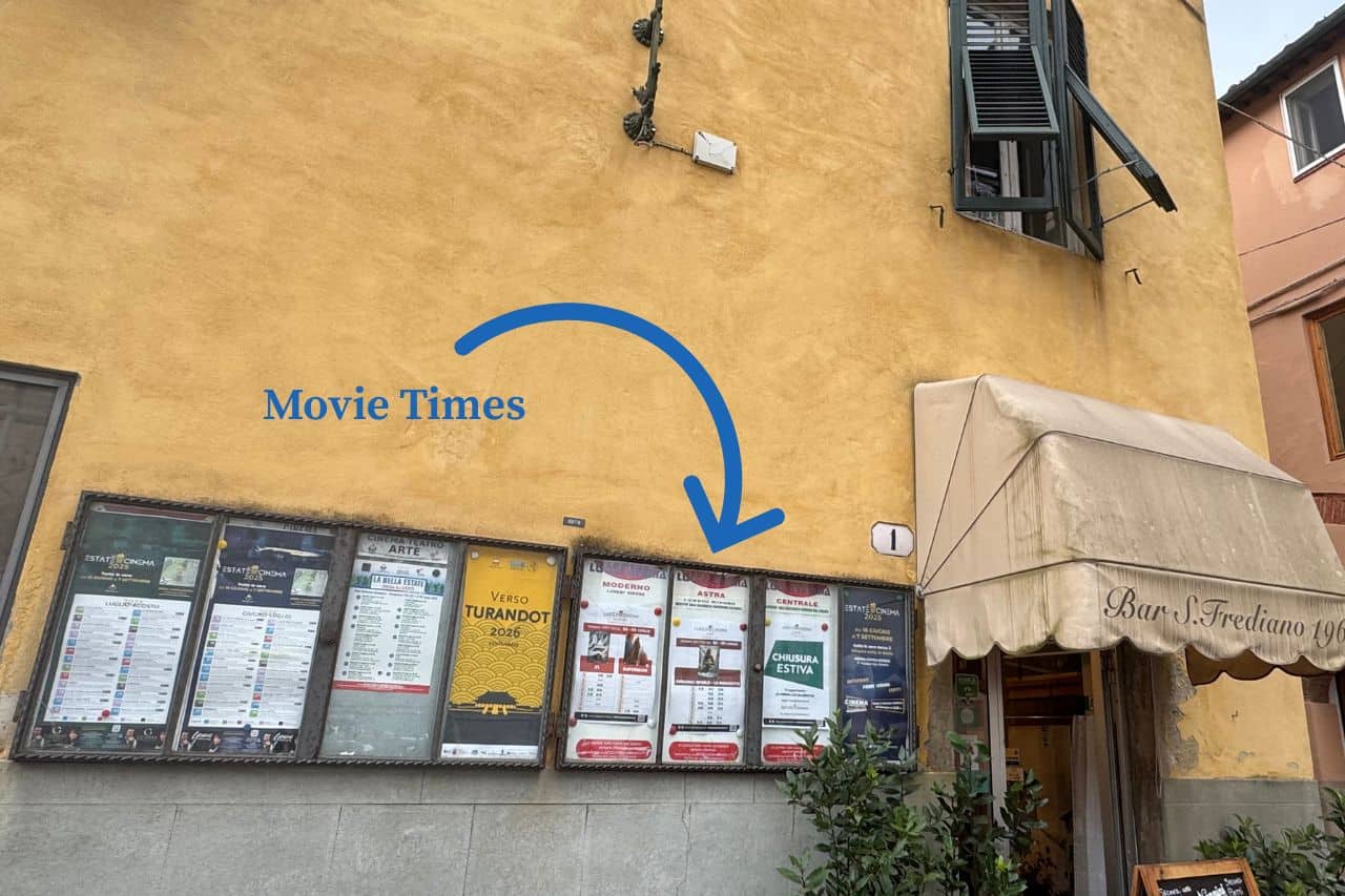 Wall display showing movie times at a cinema Lucca Italy, including English language screenings on Sundays