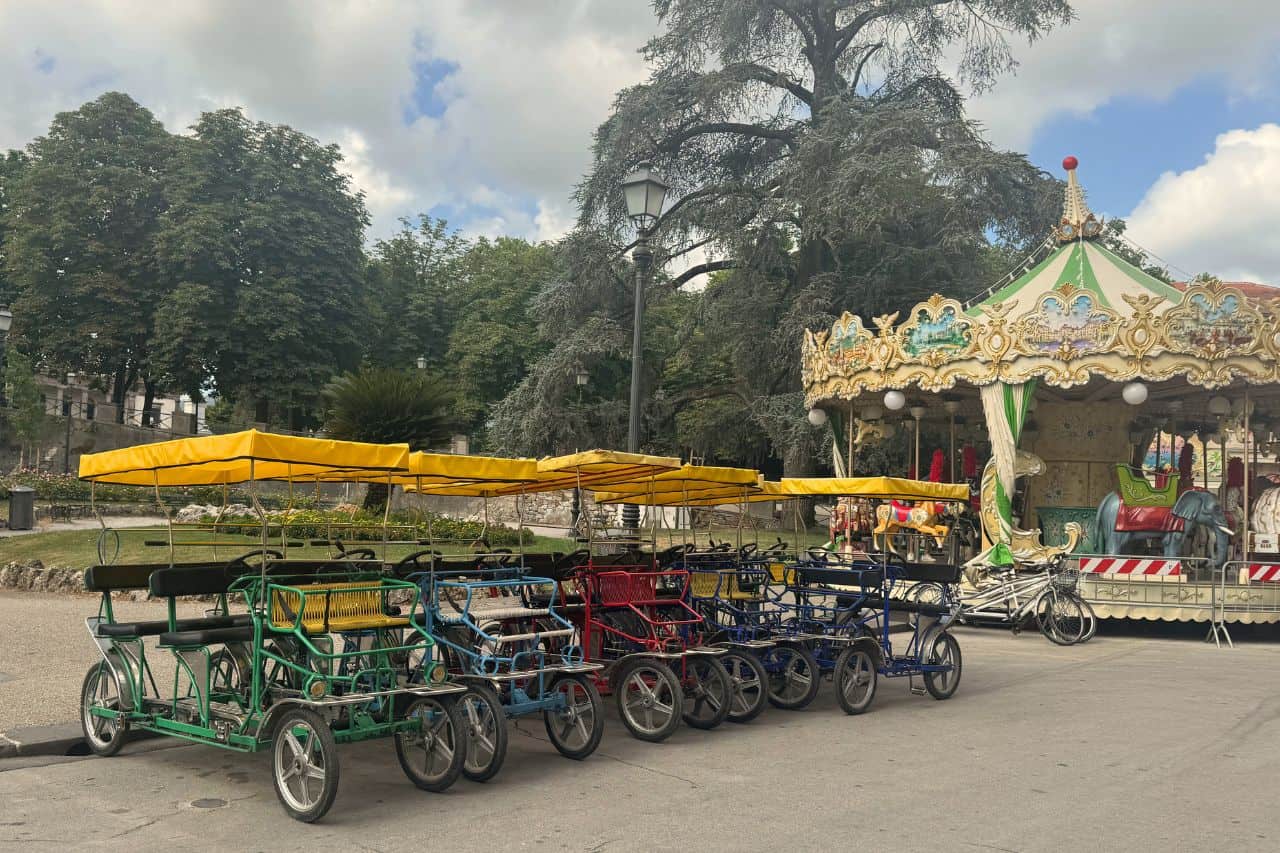 Colorful pedal carts lined up for rent on the streets of Lucca Italy, perfect for group rides around the city walls