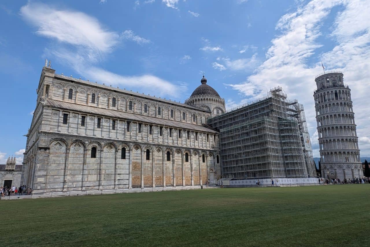 Backside view of Pisa Cathedral with the Leaning Tower rising behind it in Piazza dei Miracoli