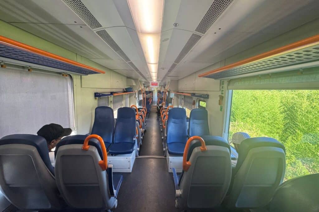 Empty seats and overhead storage on a regional Trenitalia train heading to Lucca