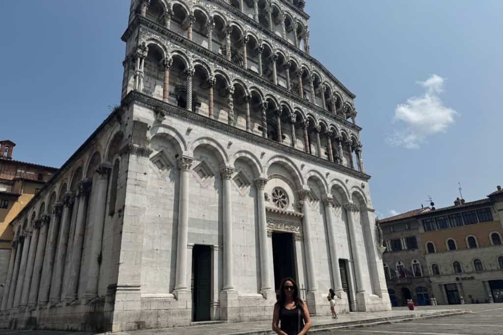 Woman posing outside a historic church in the center of Lucca Italy