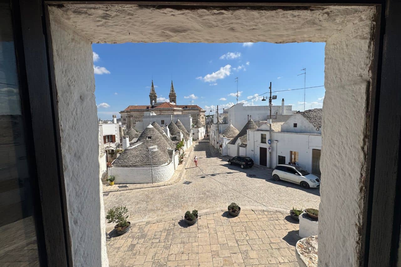Cluster of traditional cone-roofed Trulli houses in Alberobello under a clear blue sky