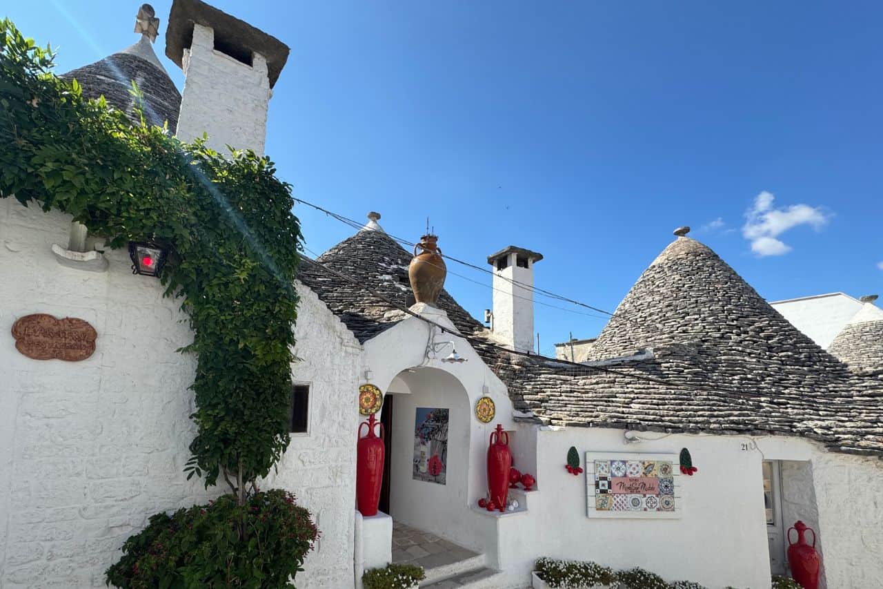 Detailed view of a white Trulli house with a pointed stone roof in Alberobello