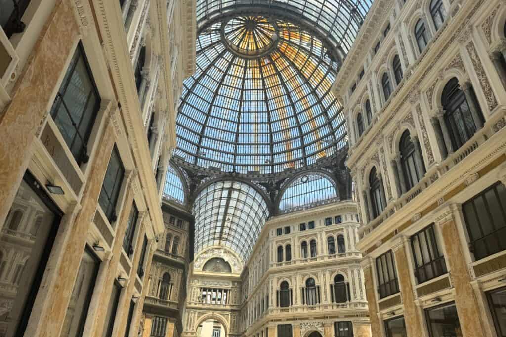 Ornate glass and iron dome ceiling of Galleria Umberto I, showcasing 19th century architecture in Naples Italy