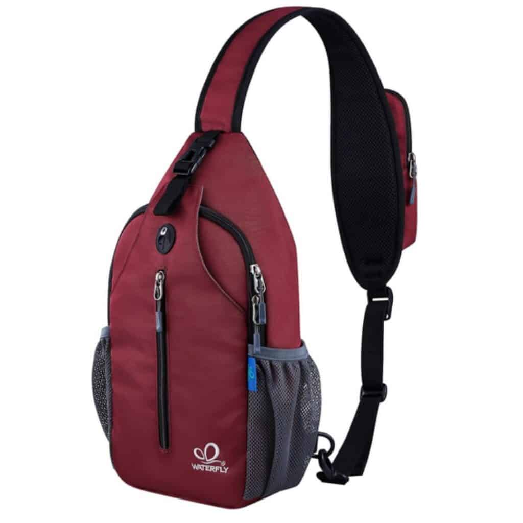 Red Waterfly sling backpack with adjustable shoulder strap, zippered compartments, and mesh side pockets