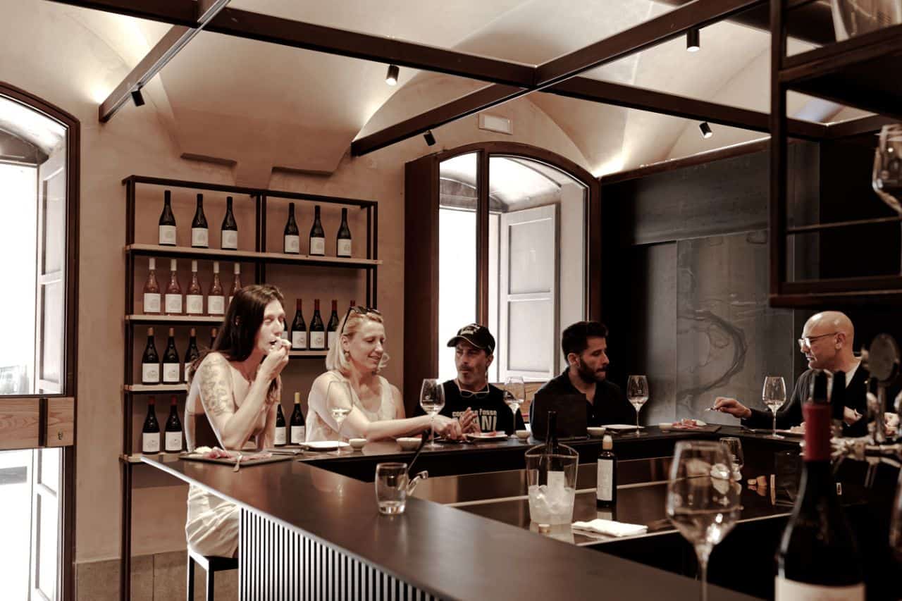 Visitors enjoying a guided wine tasting at Tenute dei Ciclopi, a wine bar and tasting room in Catania, Sicily.